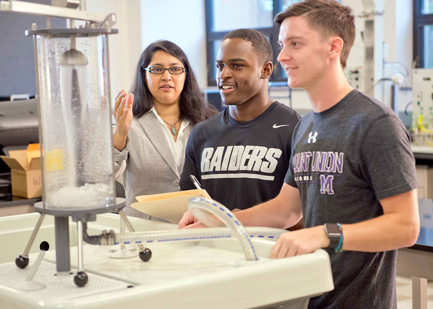 Mechanical Engineering students and professor working on an electrical water lab