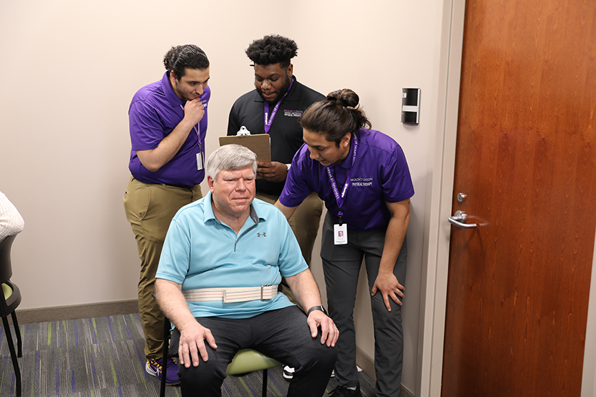 A group of Doctor of Physical Therapy students conducting an assessment on a patient