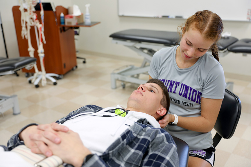 A DPT student engaging in hands-on learning during a classroom lab.