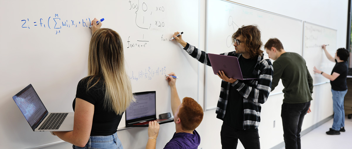 students writing equations on whiteboard