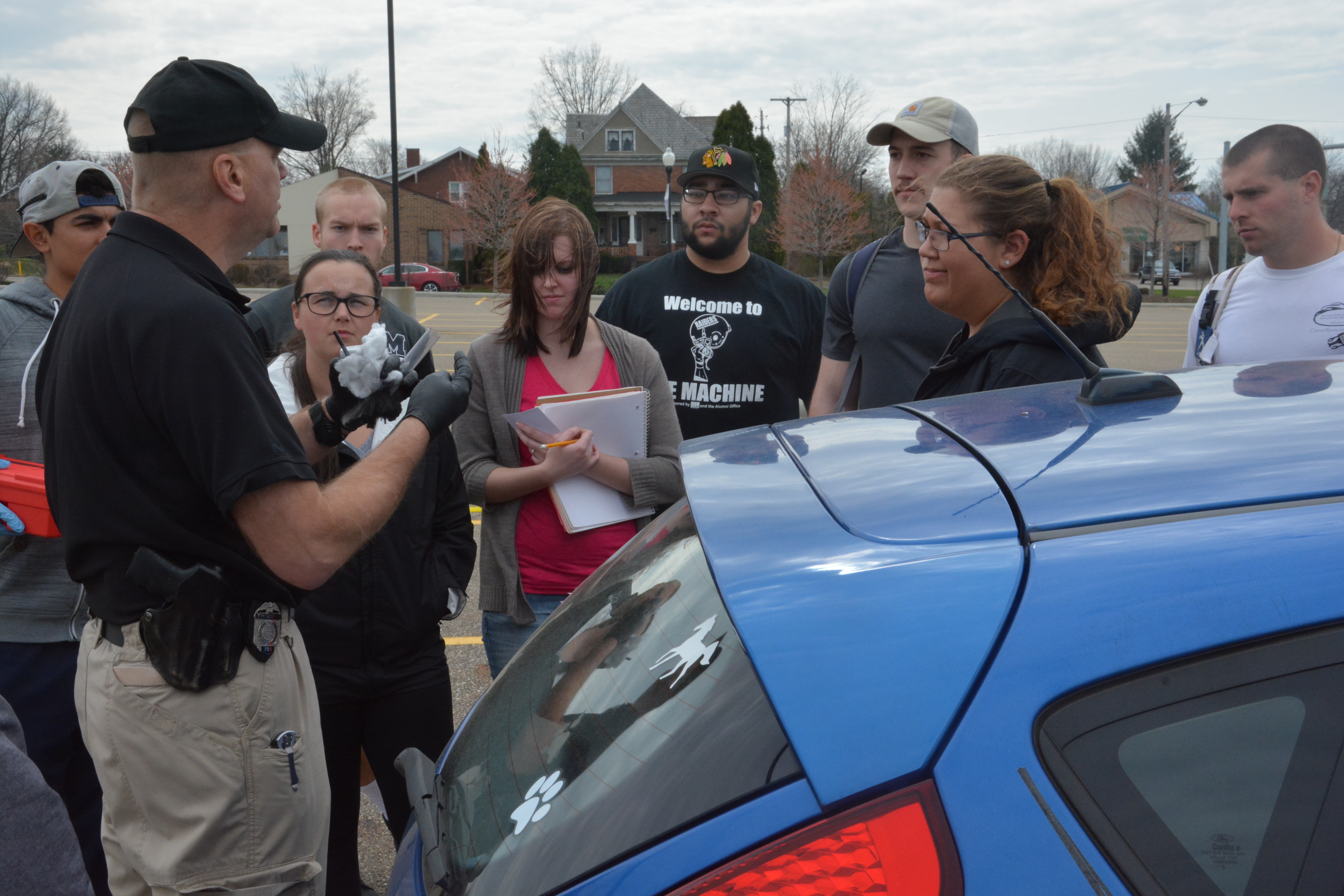 Students with a state highway patrolman at a mock crash scene