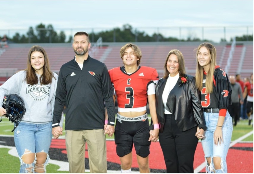 the muckleroy family holding hands on football field
